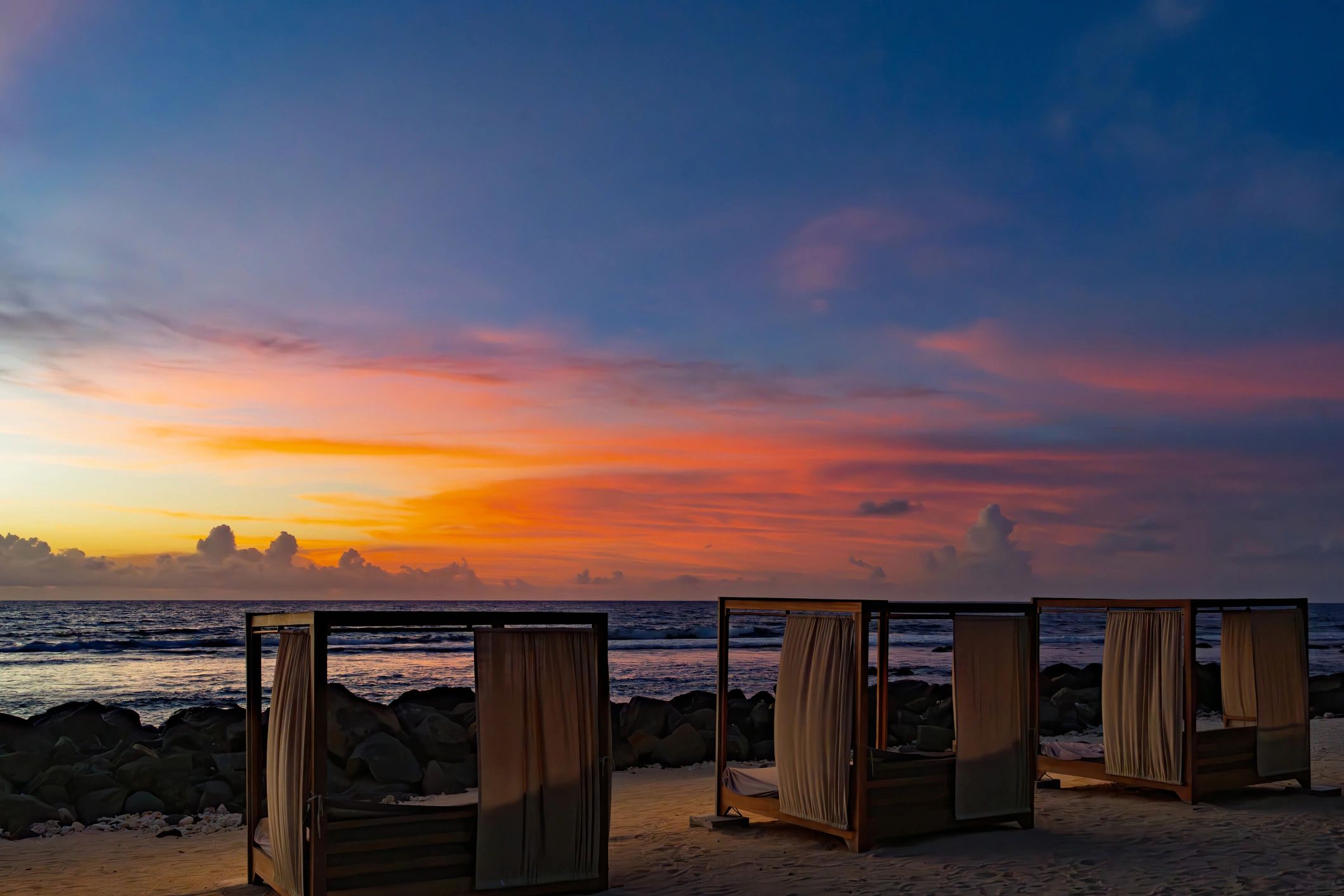 Private beach cabanas at sunset